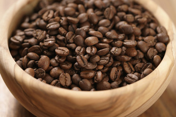 Fototapeta premium roasted coffee beans in wood bowl on table