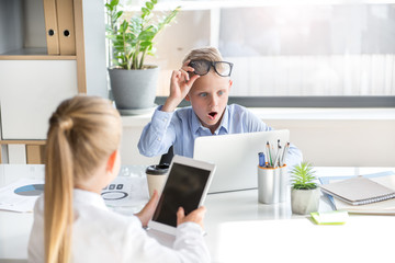 Surprised child is working with his colleague