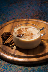 cup of spicy tea masala on wooden board, vertical