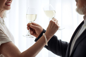 Cheerful senior loving couple drinking champagne together