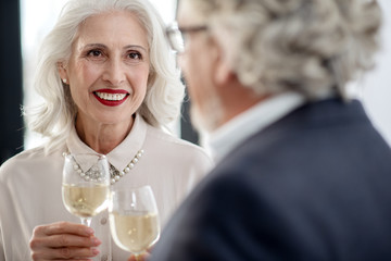 Joyful mature married couple drinking champagne on special occasion