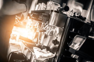Barista making coffee grinding freshly roasted coffee beans in cafe