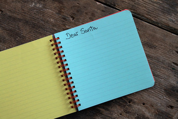 Letter to Santa Claus in colorful notebook on wooden table