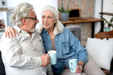 Glad elderly married couple spending time together at home