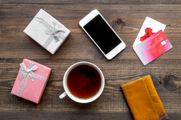 Online payment for christmas present with credit card and device on wooden background top view