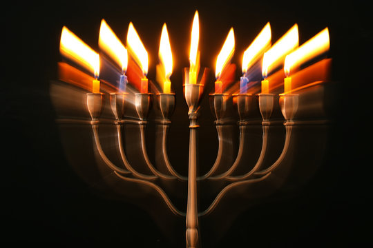 abstract image of jewish holiday Hanukkah background with menorah (traditional candelabra) and burning candles.