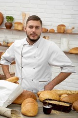 Vertical portrait of a professional baker posing at his bakery shopping selling buying food pastry delicious healthy natural organic traditional recipe concept.