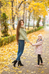 .Beautiful mom with a daughter are walking in a autumn forest or park, mother's day