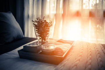 flowers pots decoration on wooden tray and napkin on bed