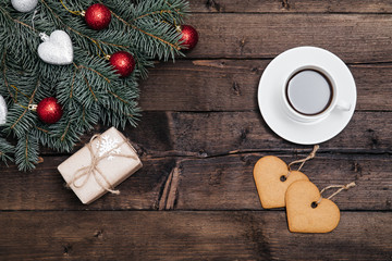 Christmas background with new year giftbox and cup of coffee on wood and xmas tree. Traditional festive Christmas dark background top view. Toned Vintage Effect.