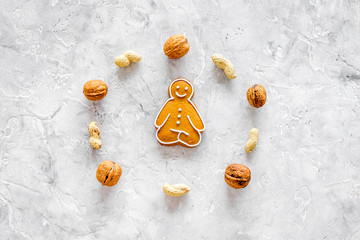 Healthy food for sportsman. Cookies in shape of yoga asanas near nuts on stone background top view...
