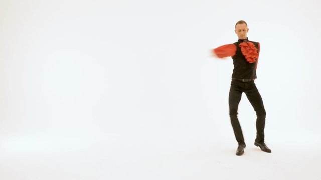 A man in a black suit and a red shirt is dancing on a white background.