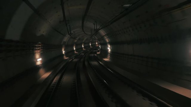 View of subway tunnel as seen from reverse of moving backward train. Fast underground train riding in tunnel of modern city.Long footage of underground train following its route
