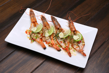 Grilled Spicy River Prawn with lime garlic and lemongrass on wooden table