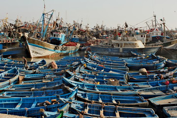 Essaouira city in Morocco. Many of blue small traditional fisherman boats in local port. Boats are on water close to each other.