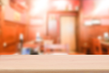 Wood table top with blur restaurant interior to promote your products