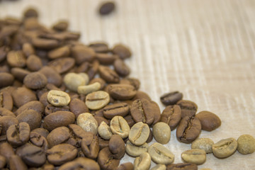 Raw and roasted coffee beans on a wooden base