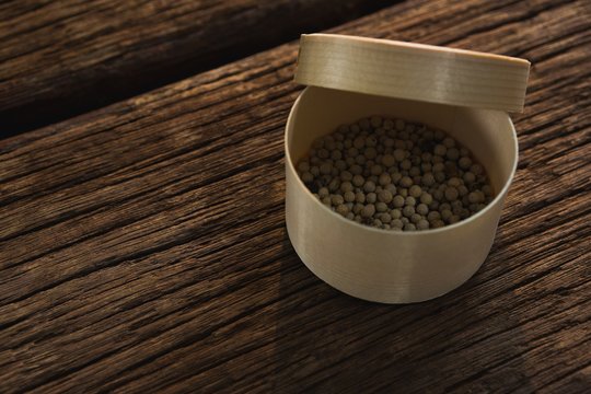 Pepper seed in a container on wooden table
