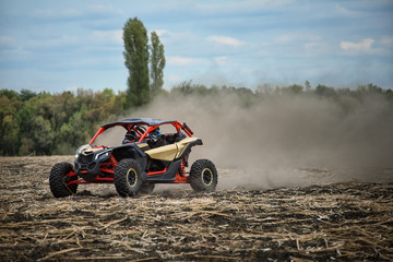 Quad bike is racing along an oblique field