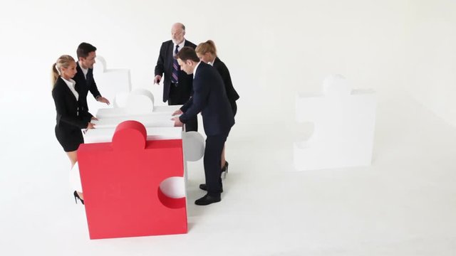 Business team assembling big puzzle on white background