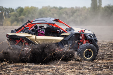 Two pilots in the cockpit of quad bike rushing through the field © alexlukin