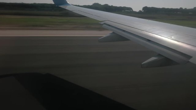 View from a jet taking off from Barcelona International Airport as seen from inside the aircraft from porthole. view of earth and sea through window with some shaking