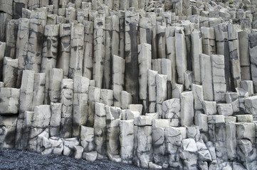 Vik  -  Reynisfjara Beach - basalt cliffs in a typical Icelandic landscape, a wild nature of rocks and shrubs, rivers and lakes.