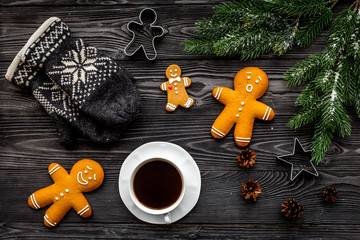 Cozy christmas evening. Coffee, cookies, spruce branch, knitten mittens on grey wooden background top view