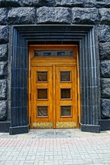 коричневая деревянная дверь на чёрной стене здания