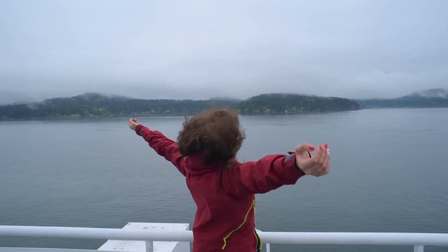 young caucasian female enjoying the view  on ferry in ocean 