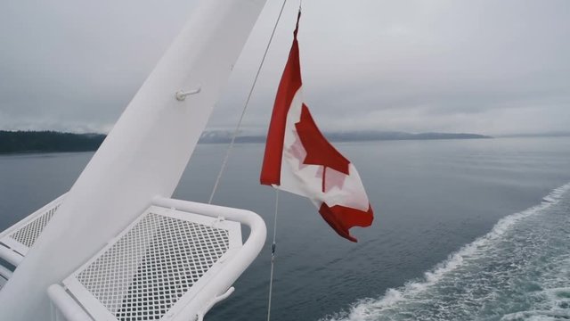 canadian flag on ship moving by the wind 