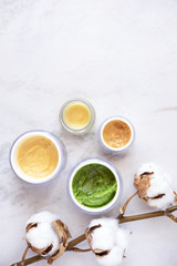 Natural skincare cosmetic products on white marble table from above. Creams, balms, masks, oils, serums.   Beauty blogger concept