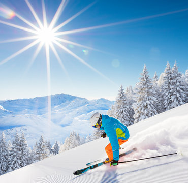 Skier skiing downhill in high mountains
