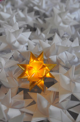 goldener Fr&ouml;belstern leuchtet inmitten vieler anderer Sterne