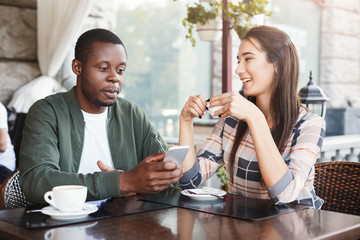 Young couple using mobile smartphones in cafe