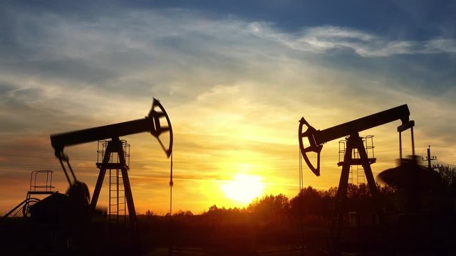 working oil pumps silhouette against sunset, timelapse 4k
