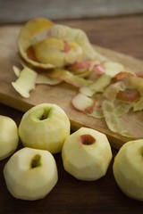 Naklejka na ściany i meble High angle view of fresh apples by peels on cutting board