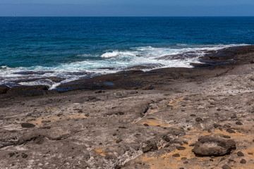 Die Brandung des Ozeans trifft auf Lavagestein
