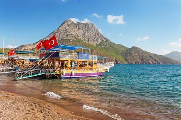 Naklejka premium Panoramic view of the coastal beach with cruise ships with turkish flags waiting for tourists