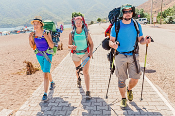 group of young happy friends students traveling along the Lycian trail with backpacks at the coastal road in the forest. Hiking and trekking in Turkey concept
