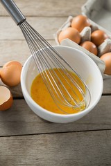High angle view of eggs in bowl and carton