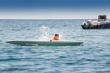 novice surfer beginner falls from the board during training in the sea