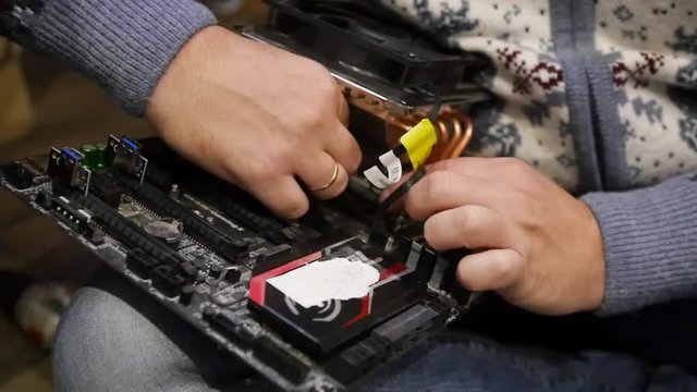 The master collects the computer with his hands, fastens the cooler to the motherboard. HD, 1920x1080. slow motion.