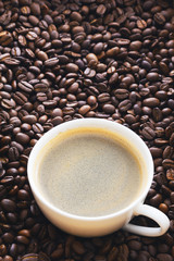 Fried coffee beans. Coffee mug on the background of coffee beans.