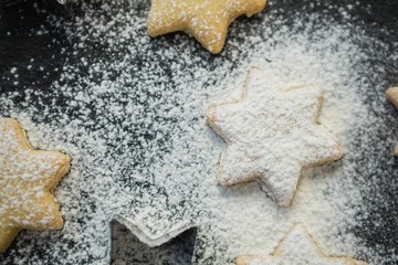 Close up of flour over star shape cookies