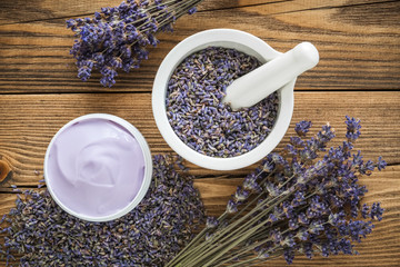 Lavender cream or balm, mortar of dry lavender and bunch of dried flowers. Top view, flat lay.