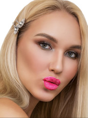 Fototapeta na wymiar Close-up portrait young blonde girl with bright makeup, pink lips, long lashes, green eyes. Plump lips in a kiss. neat clean skin