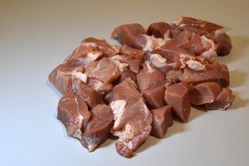 Raw lamb leg on crumpled paper background with herbs.