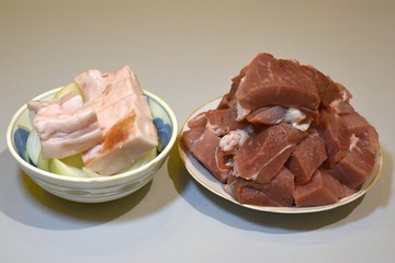 Raw lamb leg on crumpled paper background with herbs.