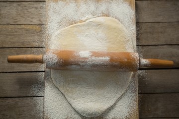 Overhead view of rolling pin on rolled dough over cutting board